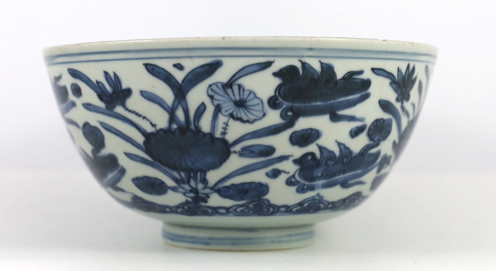 A Chinese Ming blue and white ‘lotus pond’ deep bowl, 21.5cm diameter, 10.5cm high, hairline crack to rim